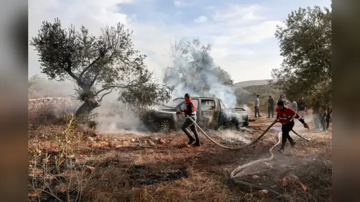 Israeli settlers attack Palestinians during West Bank olive harvest and beat U.S. photojournalist
